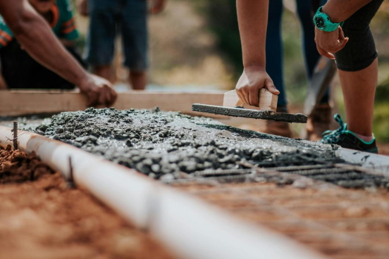 Workers pouring concrete with melamine added